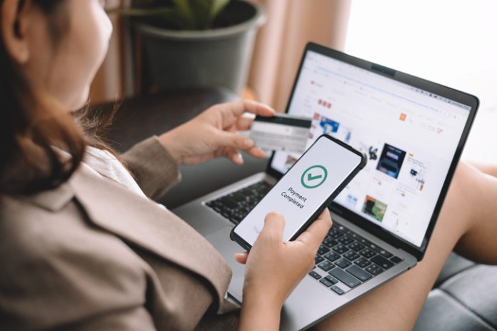 Femme asiatique détenant une carte de crédit et utilisant un ordinateur portable pour faire des achats en ligne sur un site Web à la maison, commerce électronique, services bancaires sur Internet, technologie et transfert d'argent. Concept d'achats et de paiement en ligne. shopping en ligne