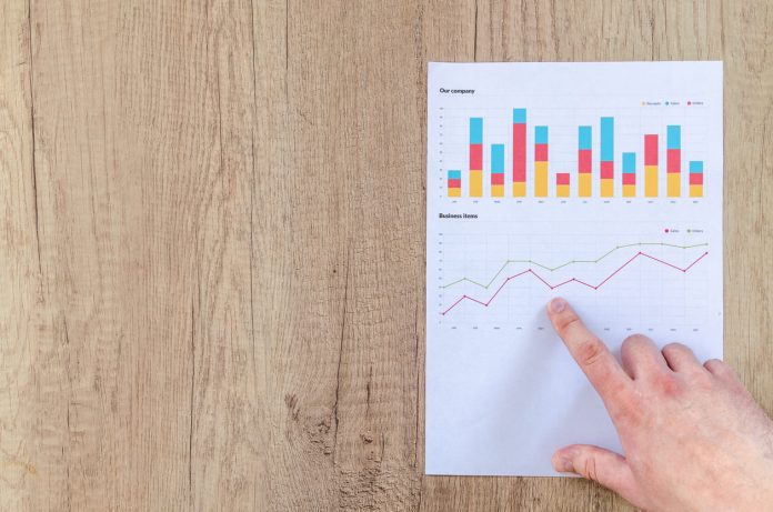 Homme montrant un graphique d'affaires sur une table en bois Atteindre la sécurité financière