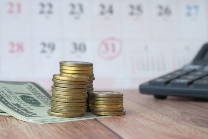 gros plan d'une pile de pièces de monnaie, d'argent liquide et d'un portefeuille sur la table prêts sur salaire